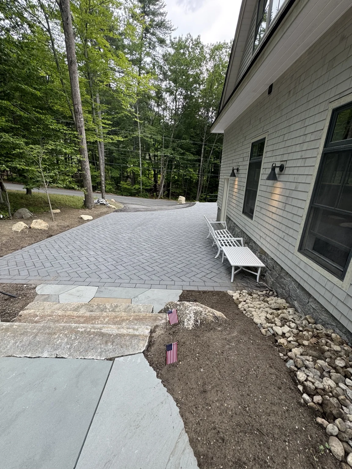 Gray paver driveway beside a New Hampshire home