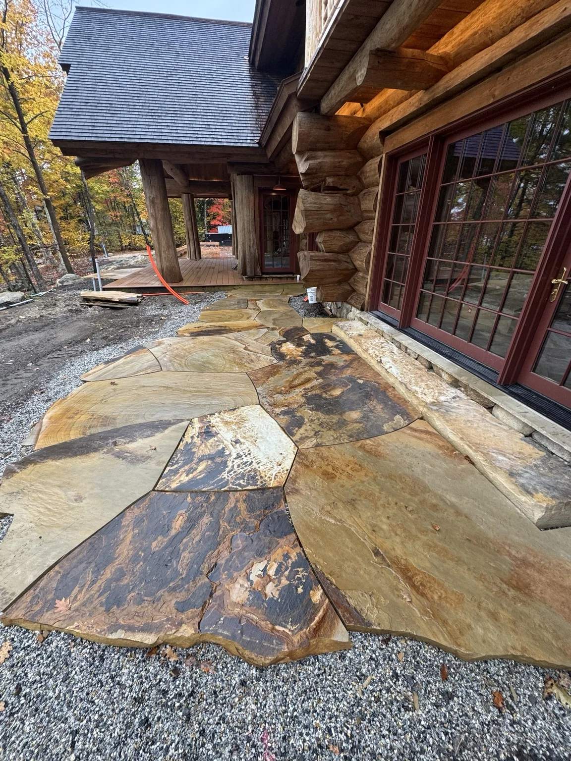 Landscaped log home with stonework by Black Bear Stoneworks