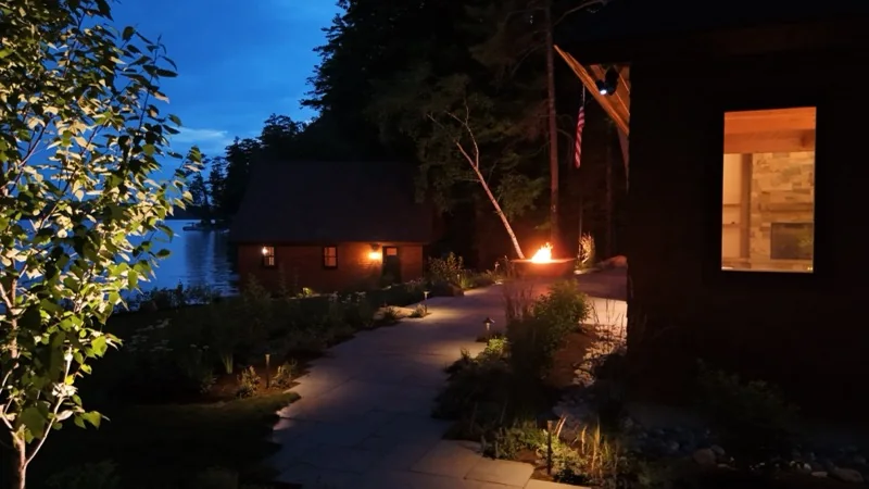 Illuminated stone walkway beside a New Hampshire lake