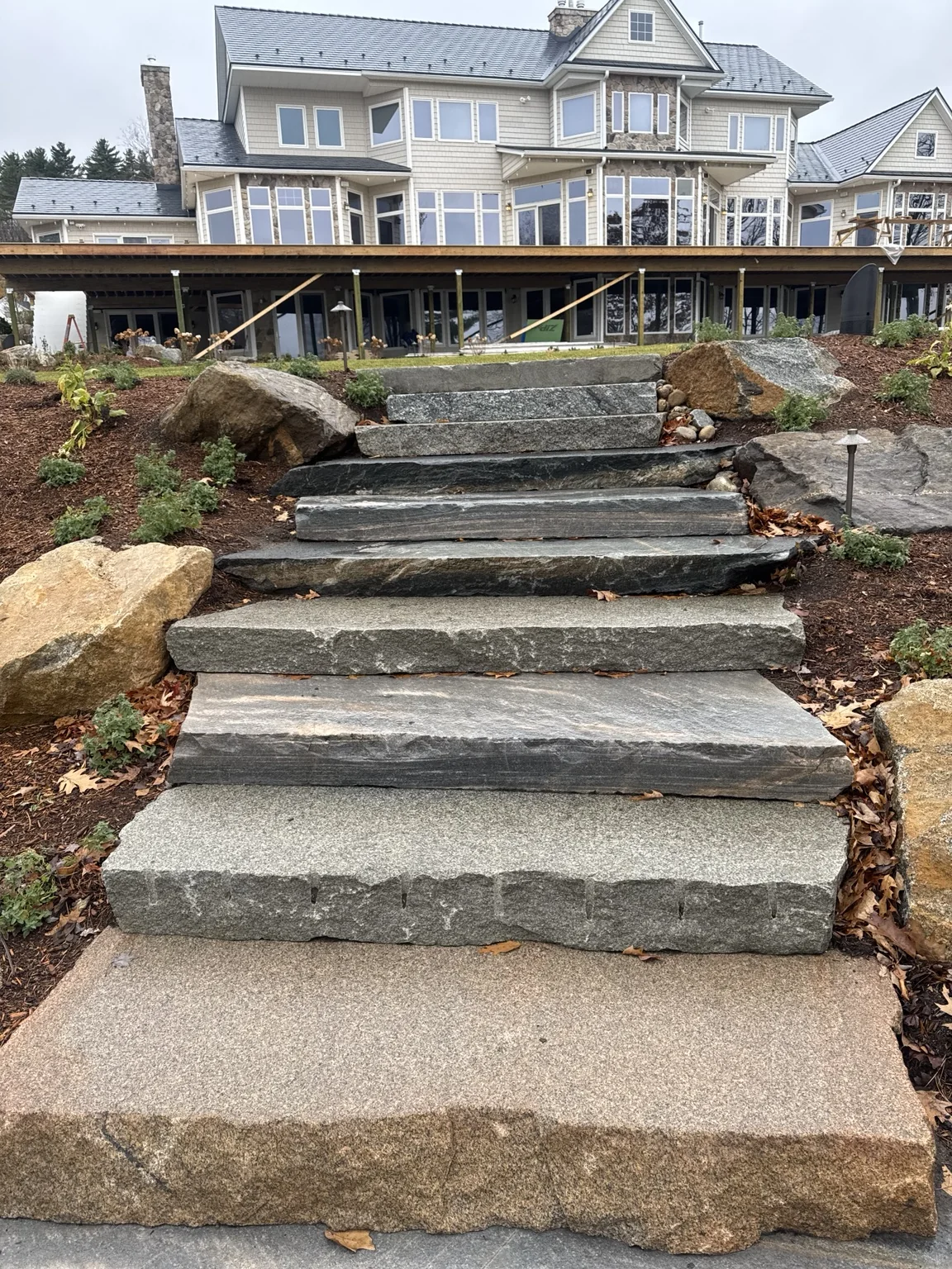 Large natural stone steps installed into a landscaped slope