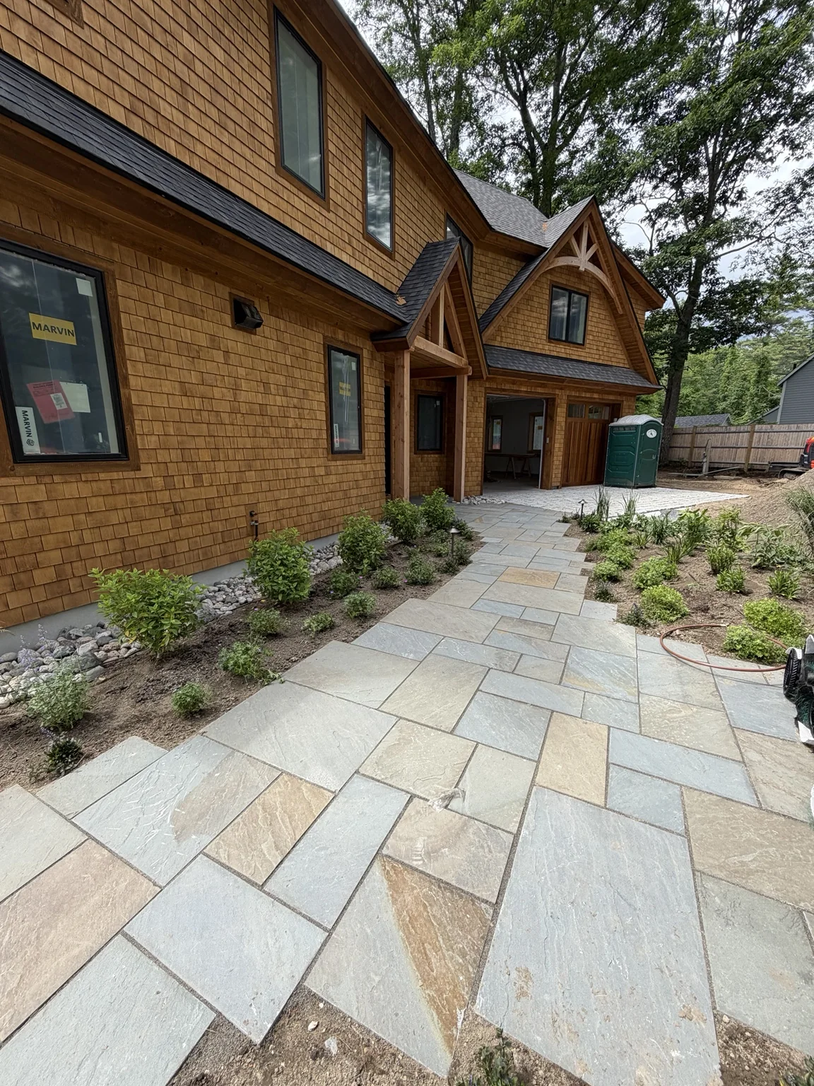 Natural stone walkway leading to a cedar home